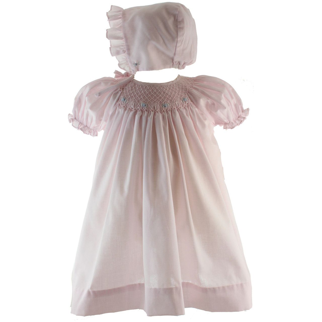 A pink smocked dress with puff sleeves and embroidered flowers, accompanied by a matching bonnet with ruffled trim.