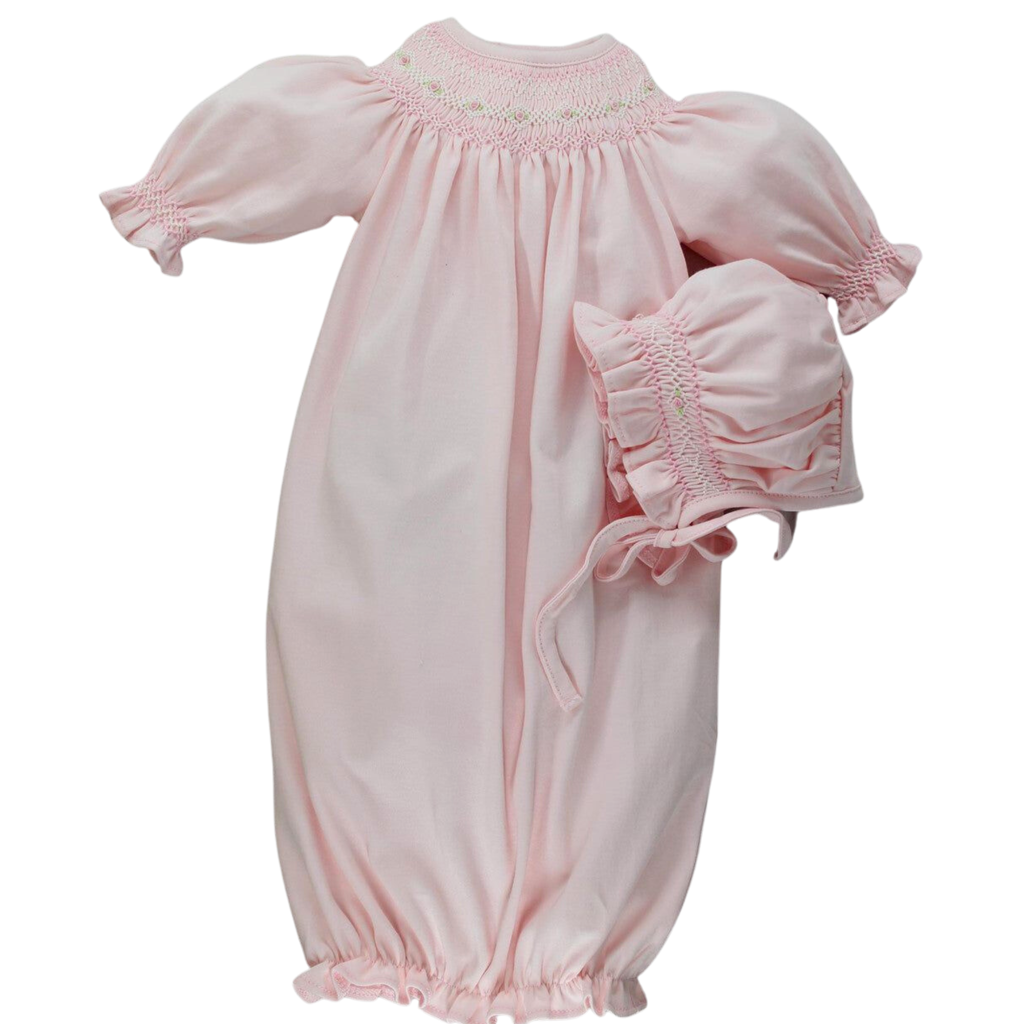 A pink long-sleeved baby gown with smocked details and a bonnet set for newborns.